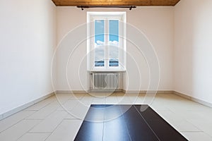 Empty room with wooden ceiling and grey tiles