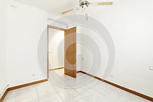 Empty room with wooden door and matching baseboard