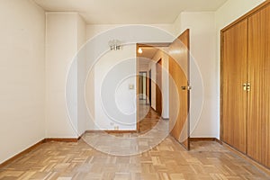 empty room with wooden doors, fitted wardrobes with matching doors, corridors with access to other rooms