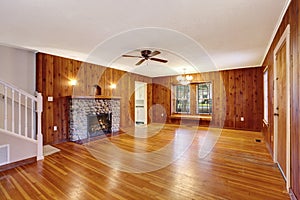 Empty room with wooden pannel trim, hardwood floor and fireplace