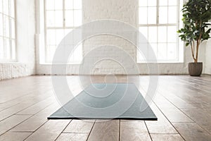Empty room in yoga studio, unrolled yoga mat on floor photo
