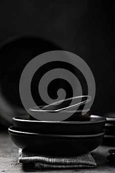 Empty round black plate on dark black background