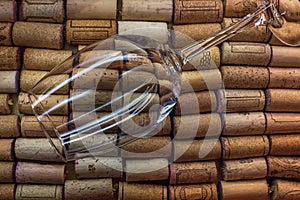 Empty round glass of wine surrounded by wine corks. Restaurant menu background