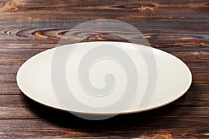 Empty round plate for food on wood bachground. Perspective view