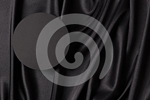 Empty round platform podium on beautiful black color background with drapery and wavy folds of silk satin material. Mock