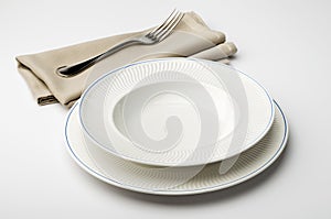 Empty round white plate and bowl with napkin and fork