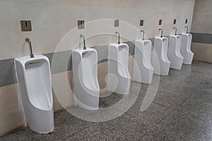 Empty row of outdoor urinals men public toilet. White ceramic urinals for man in toilet room. Gentlemen restroom in the restaurant