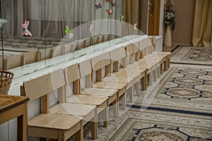 Empty row of wood children chairs in music room before celebration in music-hall waiting party