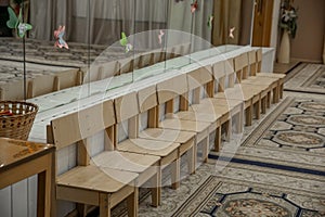 Empty row of wood children chairs in music room before celebration in music-hall waiting party