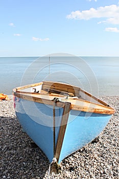 Empty rowing boat on ashingle beach
