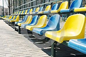 Empty rows of blue and yellow seats on the school sport court, outdoor