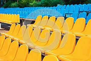 Empty rows of seats in the stadium. Blue and yellow chairs, nobody present at a sport show simple abstract concept