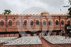 Empty rows of white plastic chairs set up for an outdoor