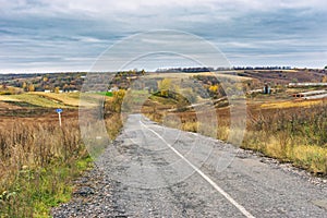 Empty rural road at cloudy autumnal day in Sumskaya oblast, Ukraine