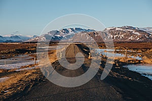 empty rural road and snow-covered mountains