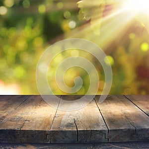 Empty rustic table in front of green spring abstract bokeh background. product display and picnic concept.