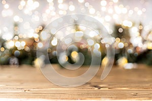 Empty rustic wooden table with blurred Christmas lights at background. Light gold bokeh of cafe restaurant in dark