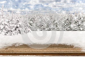 Empty rustic wooden table in snowy winter landscape. Copy space background for product or text