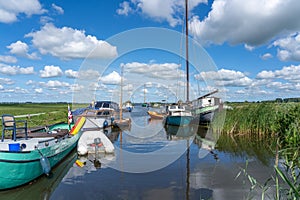 Empty sailboats and pleasure craft are anchored in the water