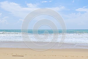 Empty sandy beach with sea under blue sky