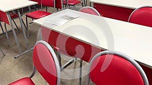 empty school class with red chairs with papers on desks. video