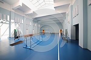 Empty school gymnasium with blue floor and photo