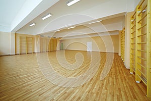 Empty school gymnasium floor with yellow and photo