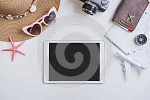Empty screen tablet with travel accessories and items on white background with copy space