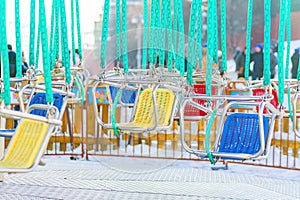 Empty seats of childrens carousel in  a cloudy day