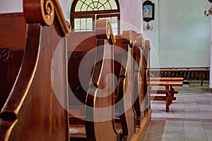 Empty seats for people in a Catholic Church. Details of religious architecture