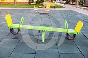 Empty seesaw on playground with soft rubber flooring in public park