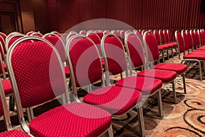 Empty seminar conference room with rows of red seats