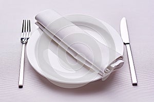Empty served restaurant table with white tablecloth
