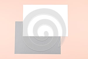 Empty sheets of white and gray paper on pink background.