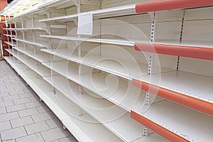 Empty shelves in the store. Supermarket with empty shelves for goods. Concept: sale and demand for purchases, deficit, excitement