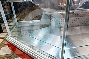 Empty shelves in a supermarket amid the coronavirus pandemic. Shopping center closure. Empty commercial fridges at