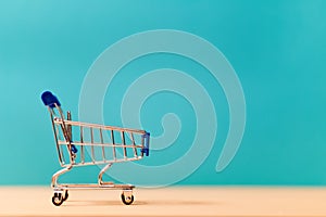 Empty shop cart miniature symbol. Small metal trolley. Shopping and purchasing goods. Retail and wholesale. Copy space