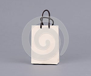 Empty shopping bag from craft paper, recycled paper shopping bag on gray background.