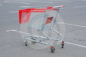 Empty shopping basket parked near a shopping center.