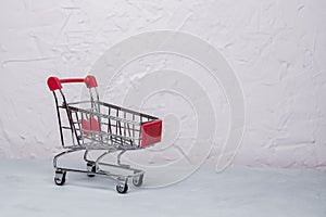 Empty shopping cart on concrete background. Soft focus