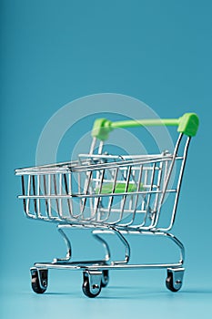 Empty shopping cart for goods from the supermarket on a blue background