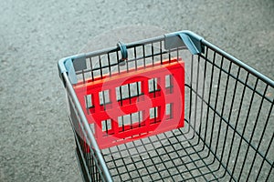 Empty shopping cart trolley in supermarket. Consumerism, shopping spree and seasonal discount concept