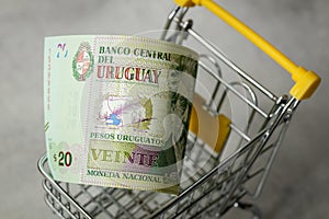 Empty shopping cart and Uruguayan money, Concept, rising prices in stores, Shopping more expensive, Inflation in Uruguay