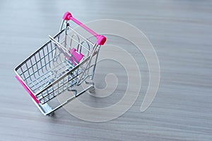 Empty shopping cart on wooden table, shopping concept