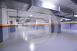 Empty shopping mall underground parking lot or garage interior with concrete stripe painted columns