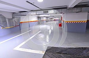 Empty shopping mall underground parking lot or garage interior with concrete stripe painted columns