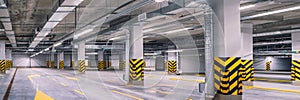 Empty shopping mall underground parking lot or garage interior with concrete stripe painted columns