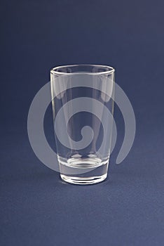 Empty shot glass stack on a dark blue background