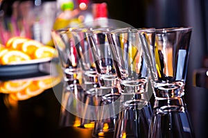 Empty shot glasses waiting on the bar counter