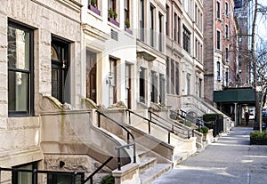 Empty sidewalk in front of old brownstone buildings in the Upper East Side neighborhood of New York City